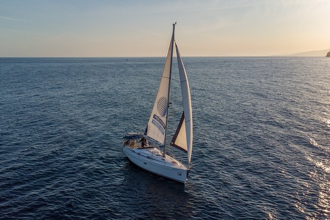 Sailing at sunset along the cliffs of Maro-Compartida - The Bavaria 37 sailing experience
